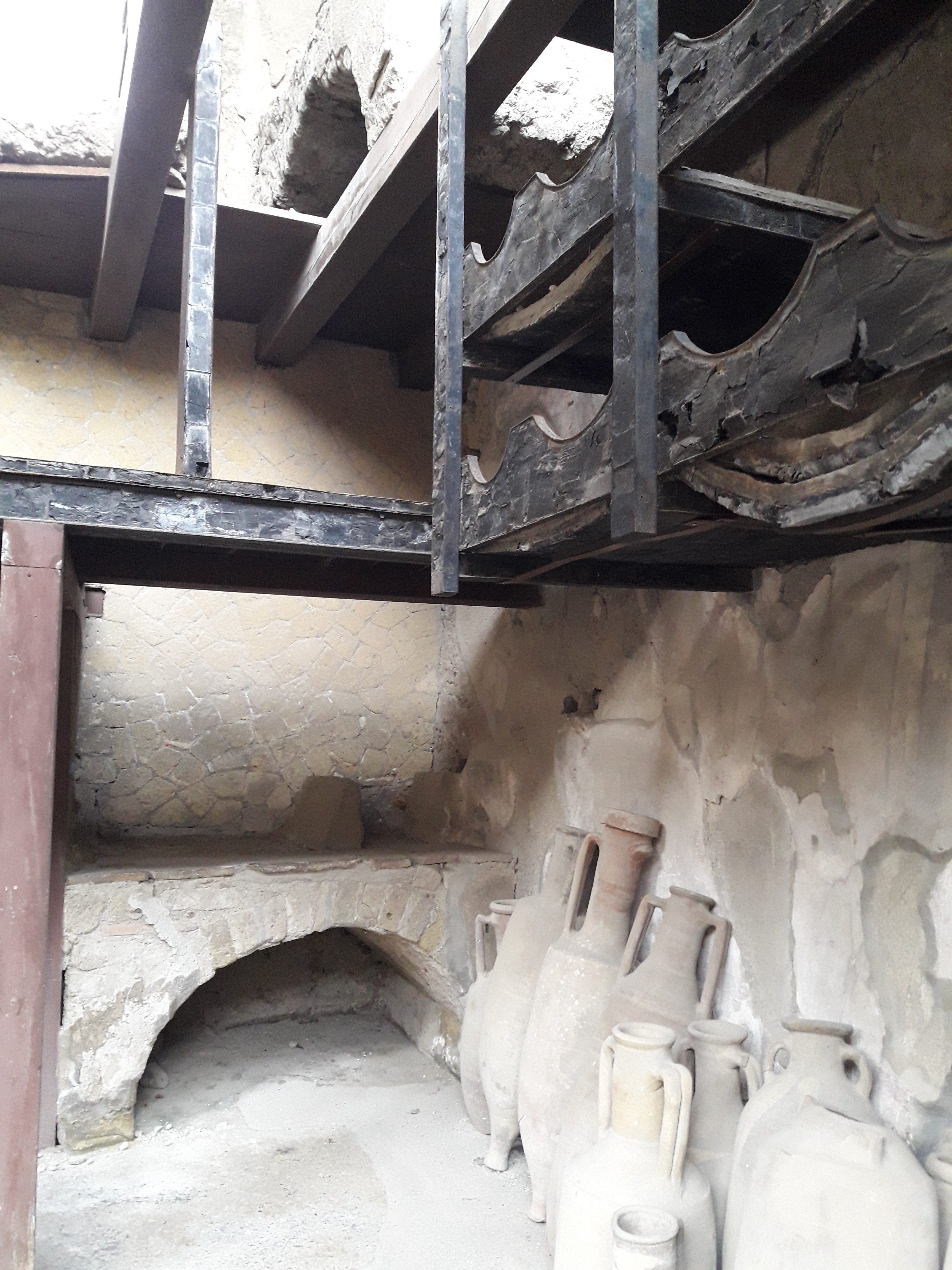 La
Bottega della casa di Anfitrite e Nettuno con i resti del
legno carbonizzato del doppio scaffale dove poggiavano le
anfore di terracotta per il vino e olio di oliva e il forno